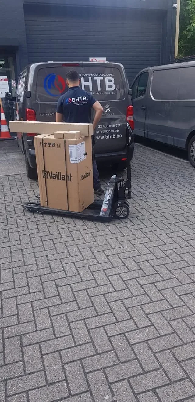 Un membre de l’équipe BHTB avec du matériel Vaillant sur un chariot